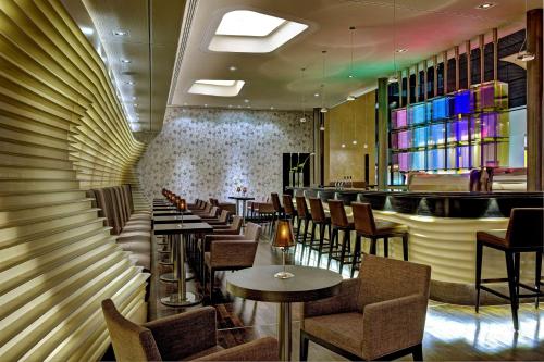 a restaurant with tables and chairs and a bar at Hilton Frankfurt Airport in Frankfurt