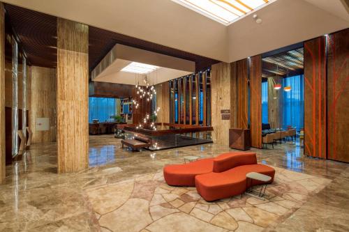 a lobby with a red couch and a chair at Hilton Garden Inn Istanbul Atatürk Airport in Istanbul