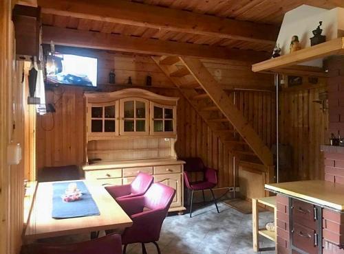 a kitchen with a table and chairs in a cabin at Domek pod Modrzewiem in Nowy Targ