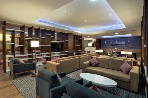 vestíbulo del hotel con sofás, mesa y sillas en Hampton by Hilton Istanbul Kayasehir, en Estambul