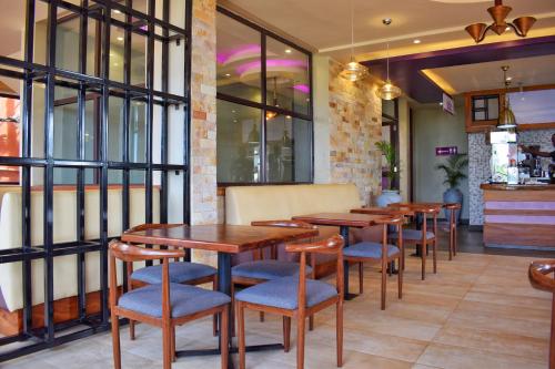 uma fila de mesas e cadeiras num restaurante em Tenda Suites and Restaurant em Entebbe