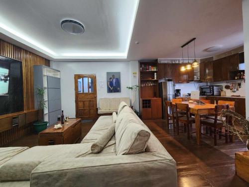a large living room with a couch and a kitchen at Lorenzo's Homestay in Basco