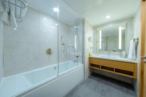 La salle de bains est pourvue d'une baignoire, d'un lavabo et d'une douche. dans l'établissement Hilton Garden Inn Safranbolu, à Safranbolu