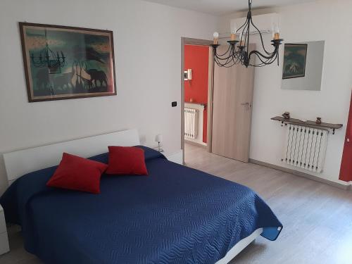 a bedroom with a blue bed with two red pillows at House Vittone Venaria Reale in Venaria Reale