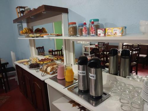 Pousada O Canto do Sabia في كانيلا: طاولة إفطار مع الطعام والمشروبات على منضدة