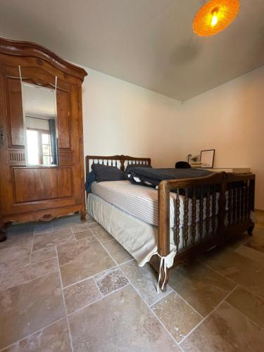 um quarto com uma cama de madeira e uma janela em Appartement cosy avec cuisine équipée et terrasse ensoleillée em Talence