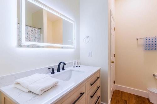 a white bathroom with a sink and a mirror at Calypso Cottage in Bluffton