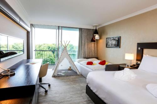Habitación de hotel con 2 camas y escritorio en Hilton Munich Park, en Múnich