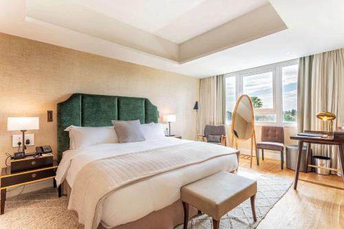a bedroom with a large bed with a green headboard at Hilton Nicosia in Nicosia