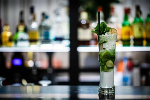 a drink with a lime and mint on a table at Hilton Nicosia in Nicosia