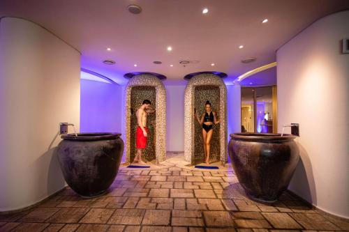two people standing in a room with two sinks at Hilton Nicosia in Nicosia
