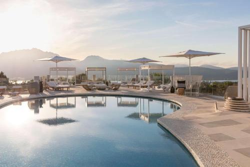 a pool with chairs and umbrellas on top of a building at Sulià House Porto Rotondo, Curio Collection by Hilton in Porto Rotondo