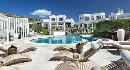 a villa with a swimming pool and lounge chairs at Sulià House Porto Rotondo, Curio Collection by Hilton in Porto Rotondo