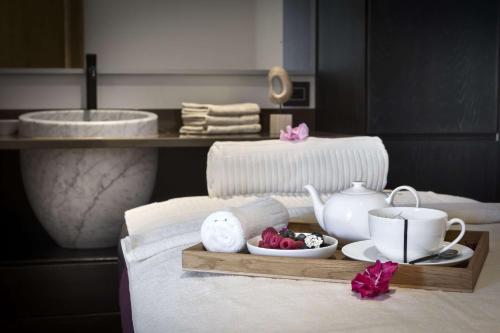 a tray with a tea set on a bed at Sulià House Porto Rotondo, Curio Collection by Hilton in Porto Rotondo