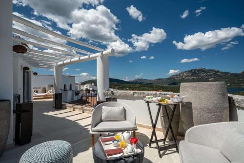 a patio with a chair and a table with a view at Sulià House Porto Rotondo, Curio Collection by Hilton in Porto Rotondo