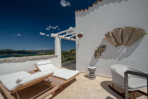 a patio with chairs and a view of the ocean at Sulià House Porto Rotondo, Curio Collection by Hilton in Porto Rotondo