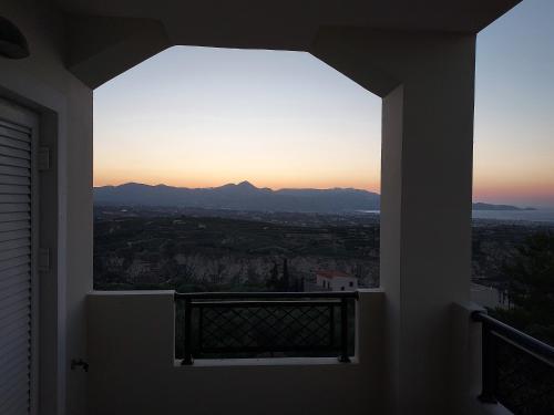 una ventana en una casa con vistas a la puesta de sol en Creta Luxury Villas, en Heraclión
