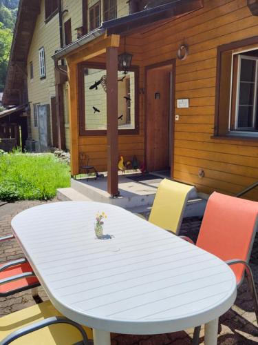 a white table and chairs in front of a house at Gemütliches Chalet in Innertkirchen