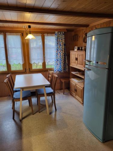 uma cozinha com uma mesa e um frigorífico em Gemütliches Chalet em Innertkirchen