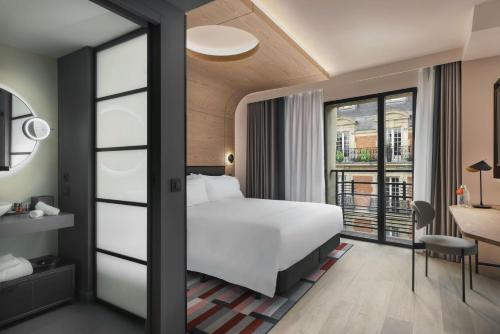 een hotelkamer met een bed en een balkon bij Canopy By Hilton Paris Trocadero in Parijs