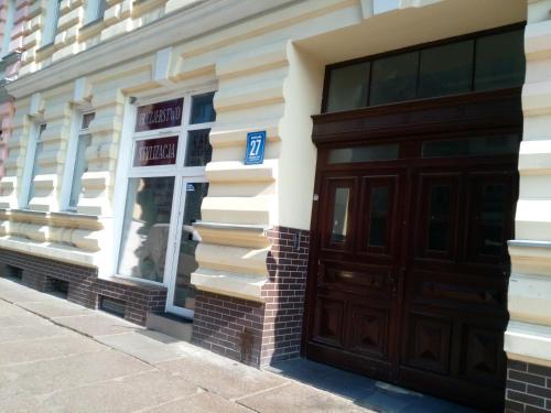een gebouw met een bruine deur en een raam bij Hostel Tulip - pokój 6 ze wspólną łazienką i kuchnią in Szczecin