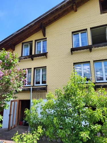 a yellow brick house with windows and trees at Gemütliches Chalet in Innertkirchen