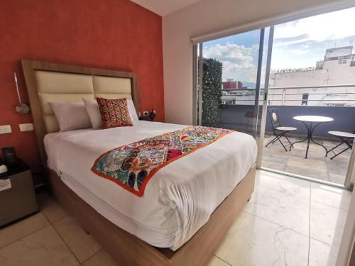 a bedroom with a large bed and a balcony at Hotel Boutique Dawat WTC in Mexico City