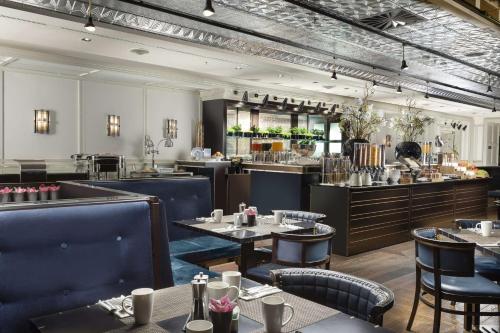 Un restaurante con mesas y sillas y un bar. en Hilton Prague Old Town, en Praga