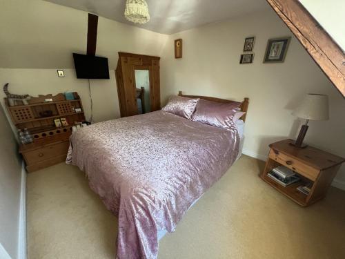 a bedroom with a bed and a table with a lamp at The Courtyard in Newmarket