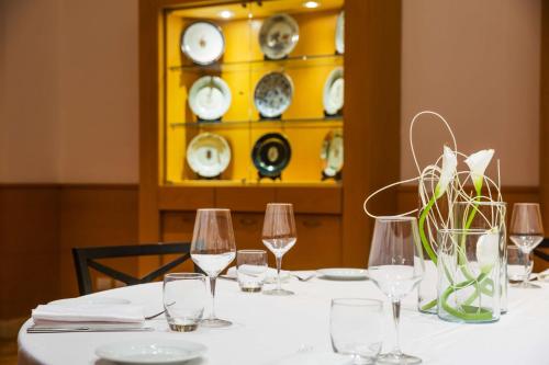 a table with wine glasses and a yellow shelf with plates at Hilton Rome Airport in Fiumicino