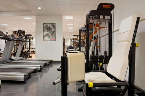 a gym with rows of treadmills and machines at Hilton Rome Airport in Fiumicino
