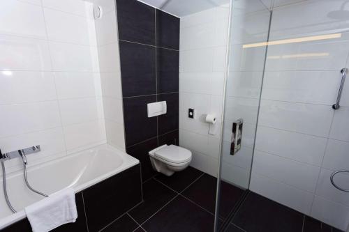 a bathroom with a toilet and a glass shower at DoubleTree by Hilton Royal Parc Soestduinen in Amersfoort