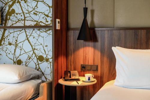 a bedroom with two beds and a table with a telephone at DoubleTree by Hilton Royal Parc Soestduinen in Amersfoort
