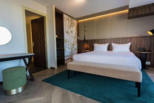 a bedroom with a large white bed and a desk at DoubleTree by Hilton Royal Parc Soestduinen in Amersfoort