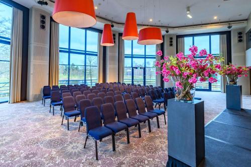 a room with a row of chairs and flowers at DoubleTree by Hilton Royal Parc Soestduinen in Amersfoort