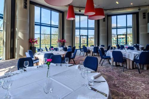 a conference room with tables and chairs and windows at DoubleTree by Hilton Royal Parc Soestduinen in Amersfoort