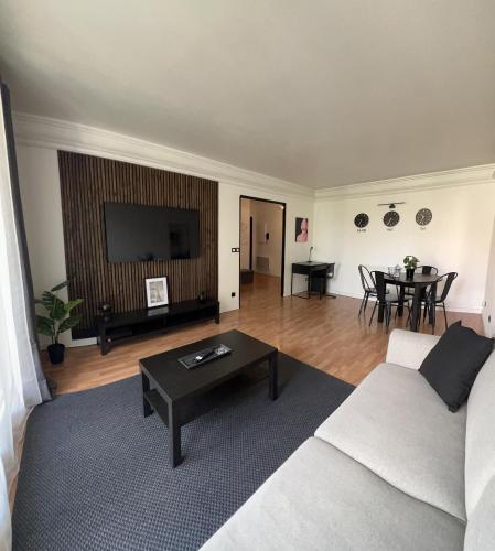 un salon avec un canapé et une table dans l'établissement Le joyau caché - Paris 2024, à Arnouville-lès-Gonesse