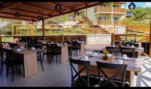 POUSADA KALUKA في بيزيروس: مطعم بطاولات وكراسي على فناء
