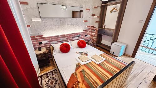 a room with a table with two red pillows on it at Guest house Mirah in Ulcinj