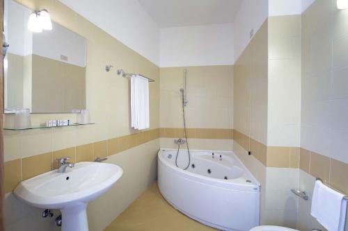 bagno con lavandino, vasca e servizi igienici di Hotel Baglio Santacroce a Valderice