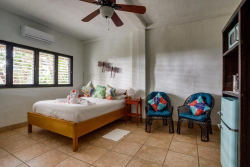 a bedroom with a bed and two chairs at Azure Del Mar in Maya Beach
