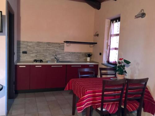 a kitchen with a table with a red table cloth at Agriturismo Bric di Gai in Monforte dʼAlba