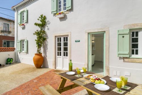 patio con tavolo in legno e cibo di Gardenland House Leiria a Leiria