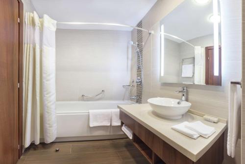 y baño con lavabo, bañera y aseo. en Hilton Garden Inn Astana en Astaná