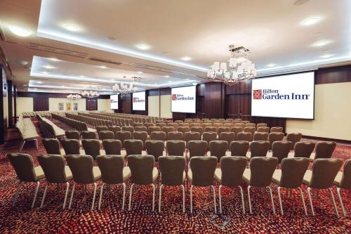 a conference room with a row of chairs and a screen at Hilton Garden Inn Astana in Astana