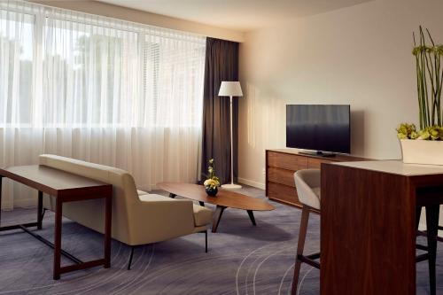 a hotel room with a living area with a television at DoubleTree by Hilton Wroclaw in Wrocław