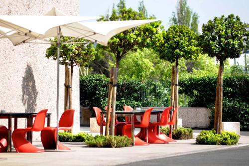 een groep tafels en stoelen met parasols bij Hilton Madrid Airport in Madrid