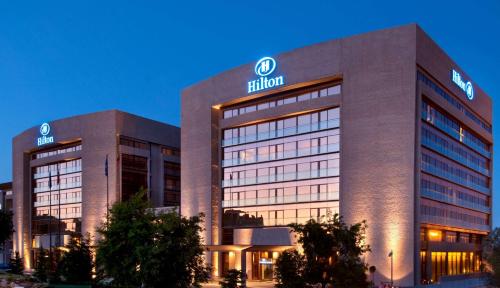 un bâtiment avec un panneau à l'avant dans l'établissement Hilton Madrid Airport, à Madrid