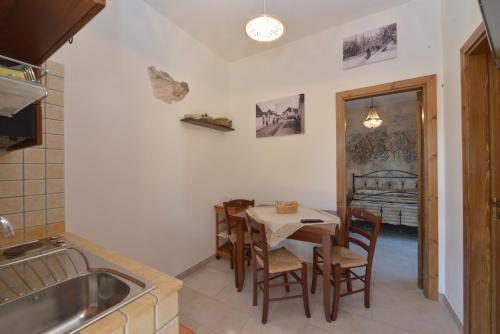 a kitchen with a table and chairs and a sink at Masseria Pentima Vetrana Resort in Alberobello