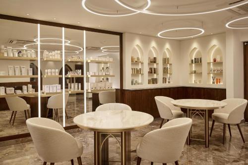 a restaurant with two tables and chairs in a room at Parklane, a Luxury Collection Resort & Spa, Limassol in Limassol
